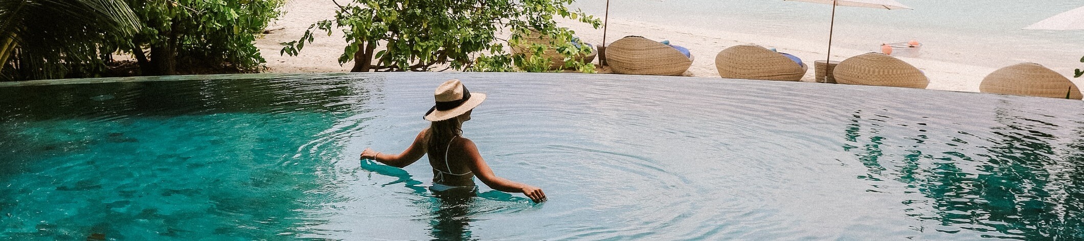 Wunderschöne Frau mit Strohhut im Urlaub mit Maxiflug entdecken